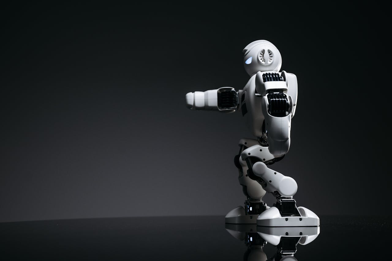 A white robot showcasing modern design on a sleek dark surface.